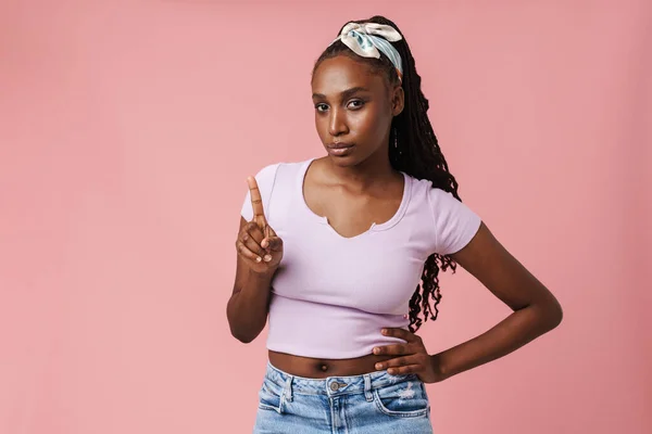 Black Young Woman Pigtails Pointing Finger Upward Looking Camera Isolated — Stock Fotó