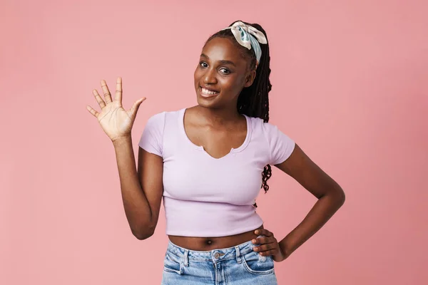 Black Young Woman Pigtails Smiling Waving Hand Isolated Pink Wall — ストック写真