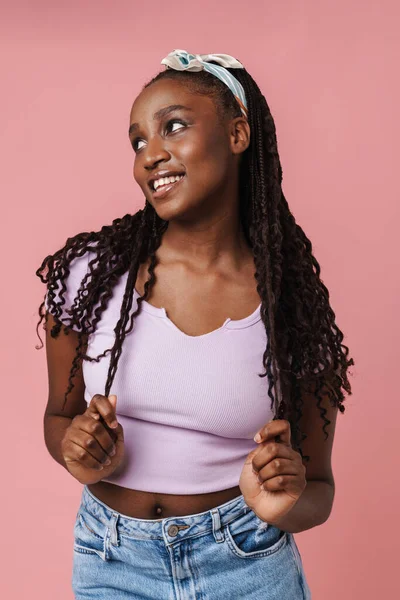 Black Young Woman Pigtails Smiling Looking Aside Isolated Pink Wall — Zdjęcie stockowe