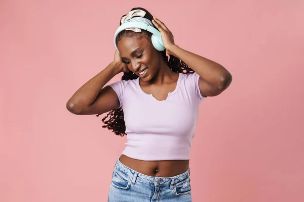 Black Young Woman Smiling While Listening Music Headphones Isolated Pink — Stockfoto