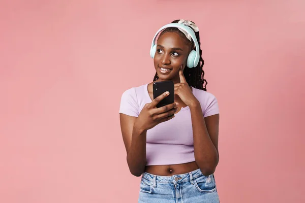 Black Young Woman Listening Music Headphones Cellphone Isolated Pink Wall — Stockfoto