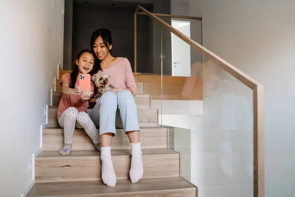 Asian Mother Daughter Taking Selfie While Sitting Dog Stairs Home — 图库照片