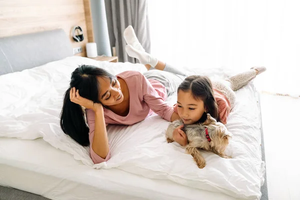 Asian Mother Daughter Smiling While Lying Bed Dog Home — Fotografia de Stock