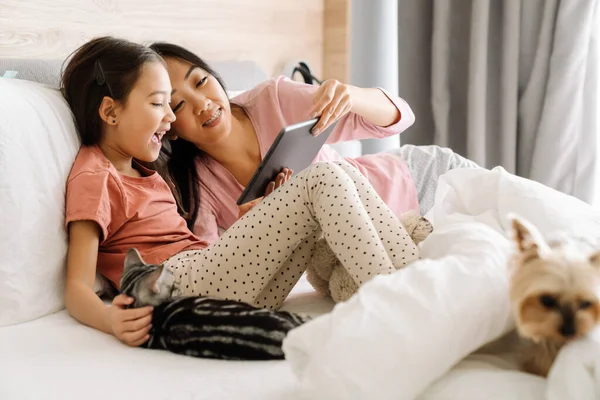 Asian Mother Daughter Using Tablet Computer While Sitting Bed Home — Stok fotoğraf