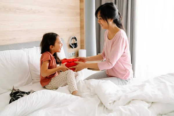 Asian Woman Giving Her Daughter Gift While Sitting Bed Home — Foto de Stock