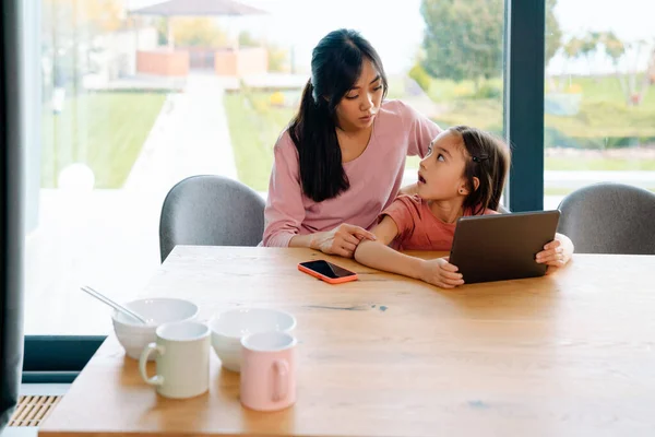 Asian Woman Her Daughter Using Tablet Computer While Sitting Table — Stockfoto