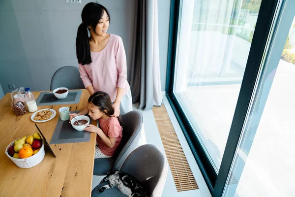 Asian Girl Using Tablet Computer While Having Breakfast Her Mother — Stock Photo, Image