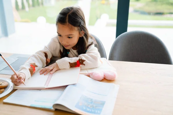 Asian Girl Doing Homework While Sitting Table Home — Fotografia de Stock