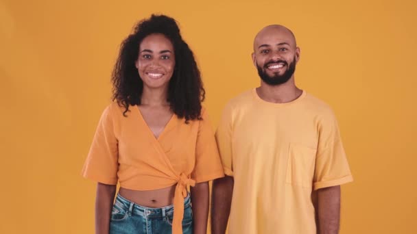 Cheerful Hispanic Couple Looking Camera Hugging Yellow Studio — kuvapankkivideo