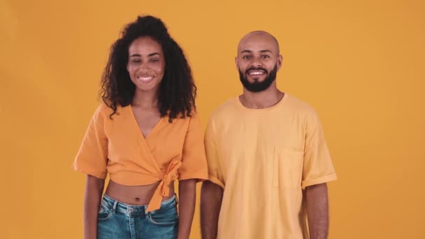 Positive Hispanic Couple Melting Camera While Standing Yellow Studio – Stock-video
