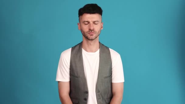 Meditative Brunet Man Wearing Vest Shirt Disagrees Something Blue Studio – stockvideo