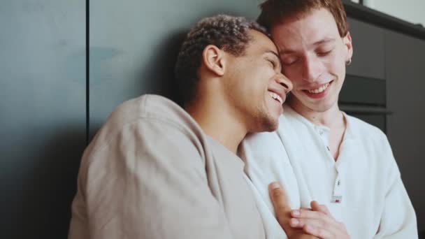 Lovely Multinational Gay Couple Hugging While Sitting Kitchen Floor — Stock video