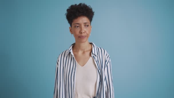 Offended Hispanic Curly Haired Woman Looking While Standing Blue Studio — Stockvideo