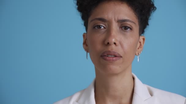 Face Pensive Hispanic Curly Haired Woman Looking Camera Blue Studio — Stockvideo