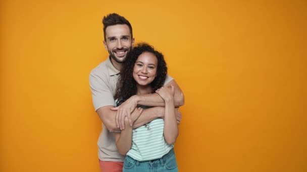 Lovely Brunette Couple Hugging Looking Camera Yellow Studio — Wideo stockowe