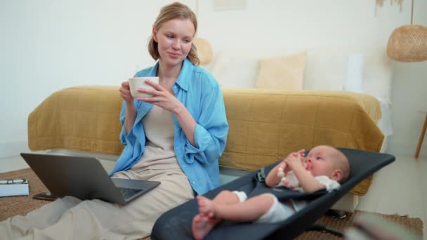 Happy Blonde Mother Drinking Tea Looking Her Small Child Lying — 图库视频影像