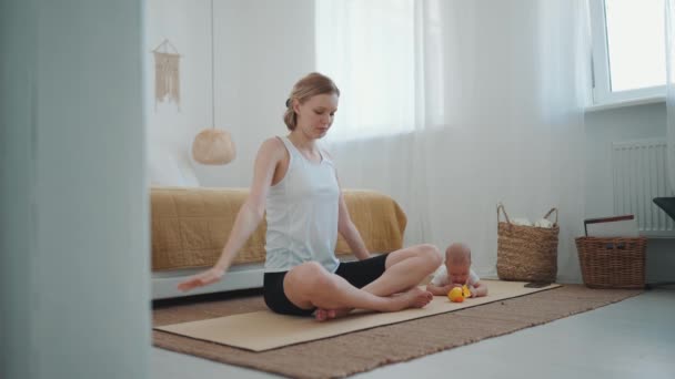 Confident Blonde Mother Doing Yoga Exercise While Her Small Child — Stockvideo