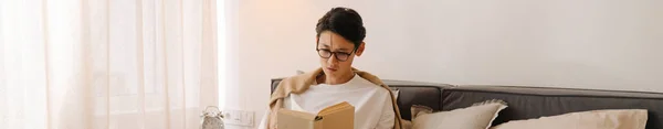 Asian Boy Eyeglasses Reading Book While Resting Bed Home — Fotografia de Stock