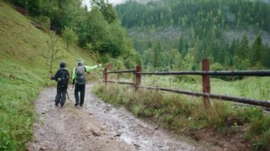 Dışarıdaki dağlarda yürüyen turist çiftin arka görüntüsü.