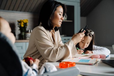Mutlu anne çocuklarıyla evde vakit geçirirken cep telefonu kullanıyor.
