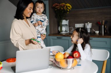 Mutlu anne çocuklarıyla evde vakit geçirirken gülüyor.
