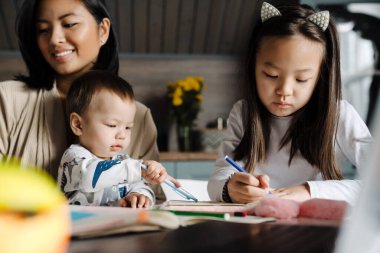 Mutlu anne evde çocuklarıyla vakit geçirirken gülümsüyor.