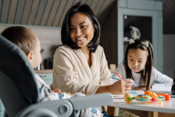 Mutlu anne evde çocuklarıyla vakit geçirirken gülümsüyor.