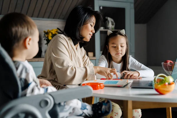 Mutlu anne evde annesiyle ödev yaparken gülümsüyor.