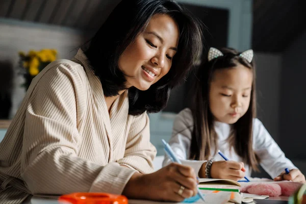Glückliche Mutter Lächelt Während Sie Mit Ihrer Mutter Hause Hausaufgaben — Stockfoto