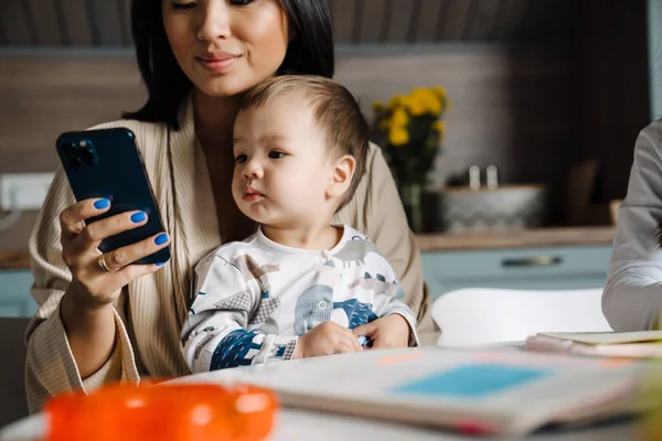Szczęśliwa Matka Korzystająca Telefonu Komórkowego Podczas Spędzania Czasu Dziećmi Domu — Zdjęcie stockowe