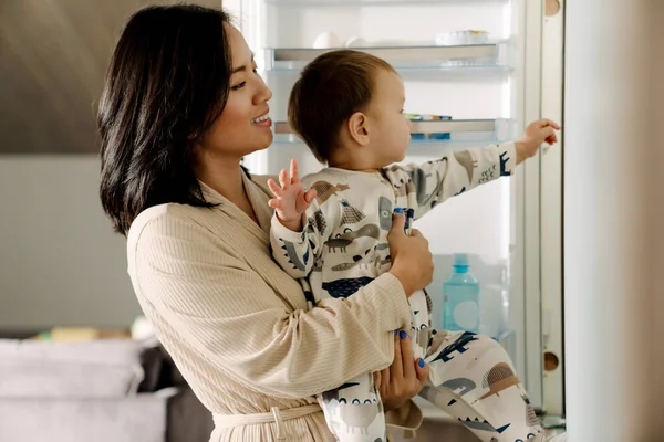 Gelukkig Moeder Houden Haar Zoon Terwijl Staan Door Open Koelkast — Stockfoto