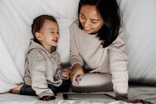 집에서 담요로 과놀면서 태블릿 컴퓨터를 사용하는 아시아 — 스톡 사진
