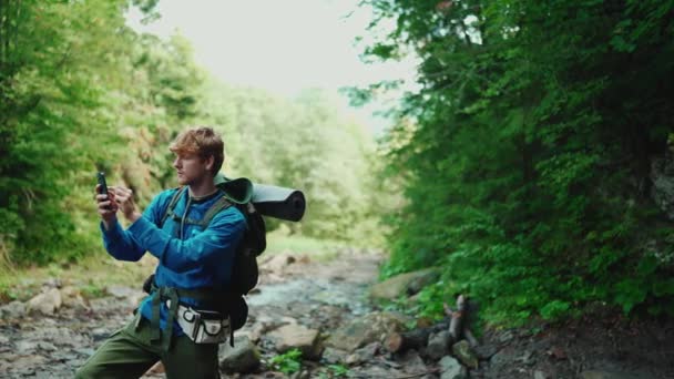 Впевнений Червоношерстий Турист Друкує Телефону Біля Річки Горах — стокове відео