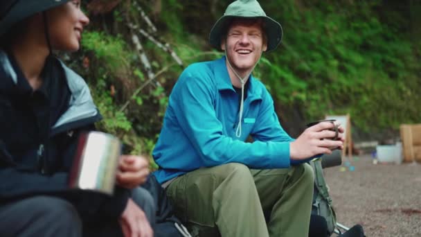 山の中でお茶を飲みながら話している多国籍観光客のカップルを笑って — ストック動画