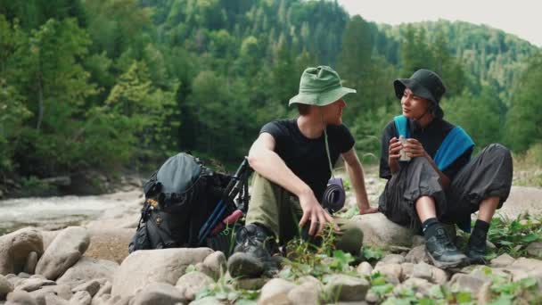 Довольно Многонациональная Туристическая Пара Разговаривает Чашкой Чая Реки Горах — стоковое видео