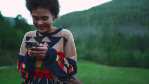 Dağlarda Ahşap Bir Çitte Otururken Cep Telefonuyla Mesaj Atan Mutlu — Stok video