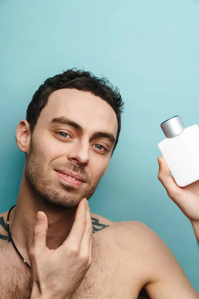 Shirtless White Man Smiling While Holding Cologne Isolated Blue Wall — Stock Photo, Image