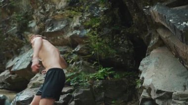 Konsantre turist kızıl saçlı adam dağlardaki nehre bir taş attı.
