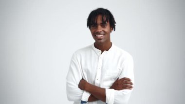 Rastalı mutlu Afrikalı adam beyaz stüdyodaki kameraya bakıyor.