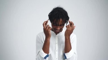 Rastalı Afrikalı olumlu bir adam beyaz stüdyoda parmakları çapraz bir şey umuyor.