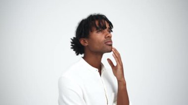 Beyaz stüdyoda düşünen, rastalı Afrikalı yakışıklı bir adam.