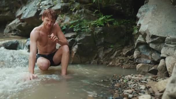 Yoğunlaşmış Turist Kızıl Saçlı Adam Dağlarda Akan Nehirde Taşa Bakıyor — Stok video