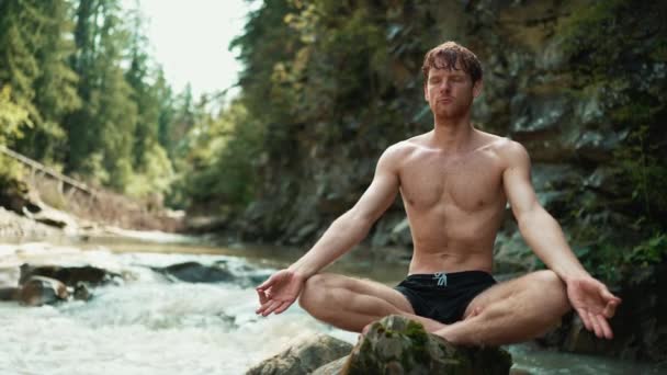Pria Berambut Merah Cantik Melakukan Meditasi Yoga Pada Batu Sungai — Stok Video
