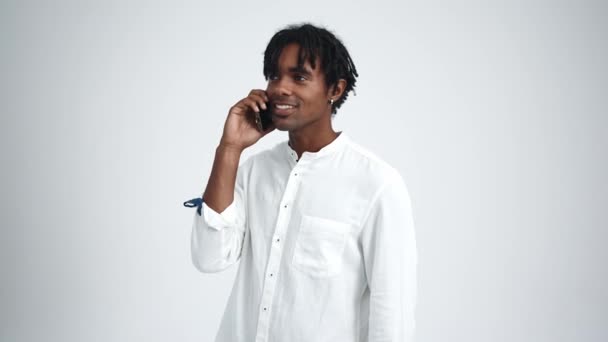 Homme Africain Positif Avec Dreadlocks Parler Téléphone Dans Studio Blanc — Video