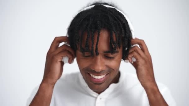 Лицо Счастливого Африканца Дредами Слушающего Музыку Наушниках Белой Студии — стоковое видео