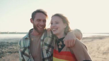 Sarışın, komik bir çift. Açık deniz kenarında sarılıp yürüyorlar.