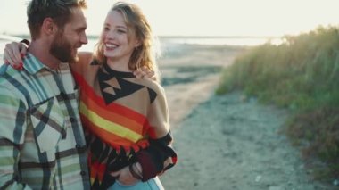 Neşeli sarışın çift dışarıda arabanın yanında konuşuyor ve sarılıyorlar.