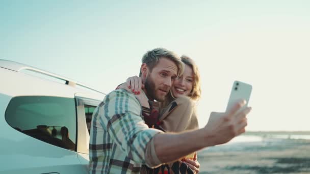 Casal Loiro Positivo Fazendo Foto Selfie Celular Perto Carro Livre — Vídeo de Stock