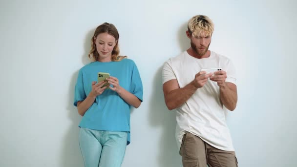 Leende Blond Ung Par Skriva Och Spela Spel Telefoner Den — Stockvideo