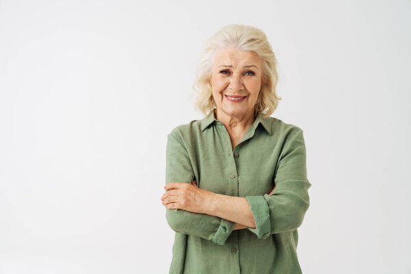 Grey senior woman in shirt smiling and looking at camera isolated over white background